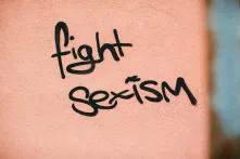 Ein Graffiti  das auf einer orangenen Wand steht und "fight sexism" sagt
