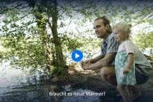 Eine männlich gelesene Person hockt am Wasser mit einem blonden Kleinkind. Im unteren Bildabschnitt steht geschrieben: Braucht es neue Männer?