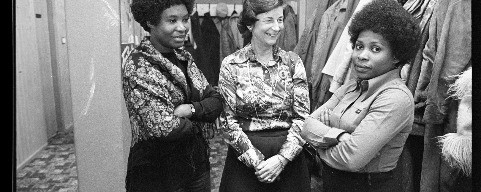 Zwei schwarze Frauen und eine weisse Frau stehen nebeneinander.